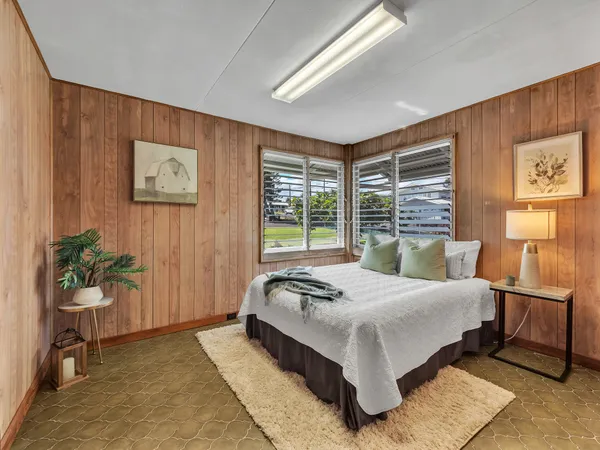 a bedroom with a large bed and potted plant