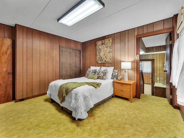 a bedroom with a bed table and closet