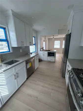 a kitchen with granite countertop a stove top oven a sink dishwasher and a stove