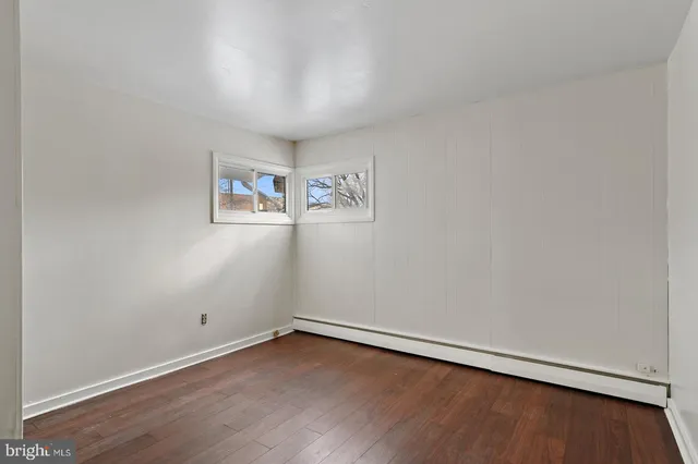 an empty room with wooden floor and window