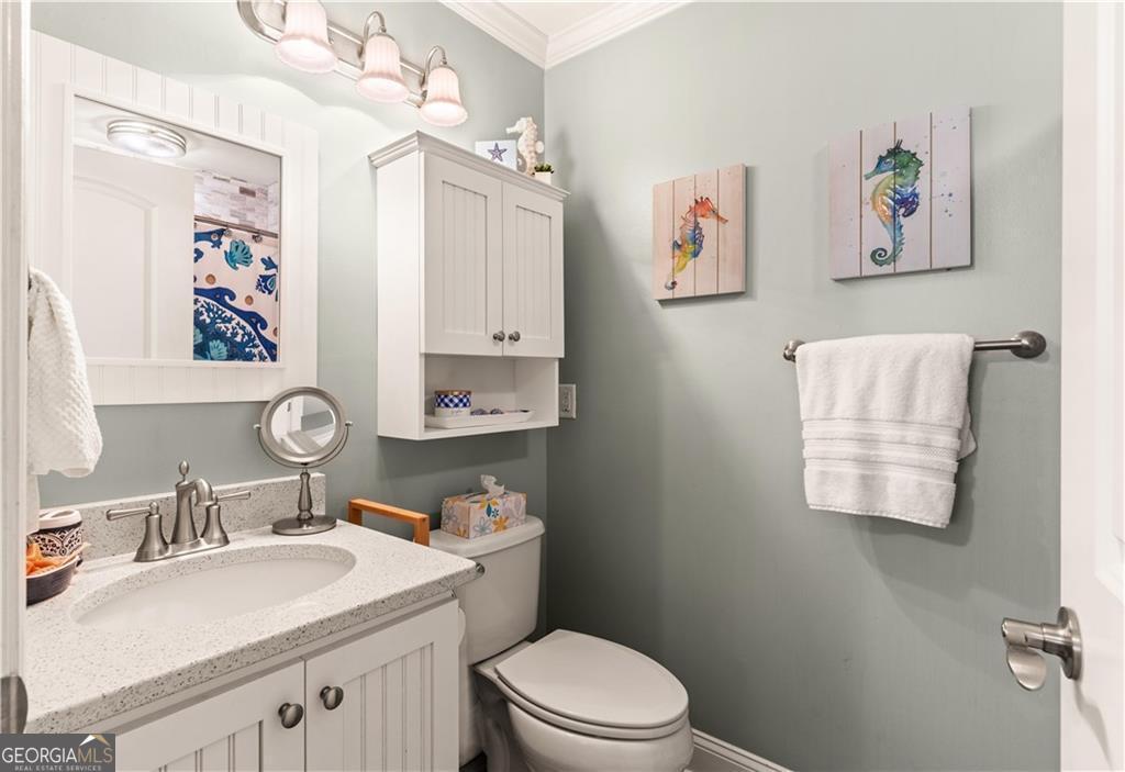 1035 Beach View Drive, Unit 201 St. Simons, GA 31522 - Photo 14 of 18 a bathroom with a granite countertop sink mirror vanity and toilet