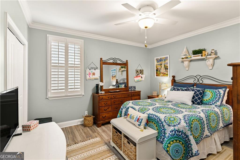 1035 Beach View Drive, Unit 201 St. Simons, GA 31522 - Photo 15 of 18 a bedroom with a bed and a chandelier