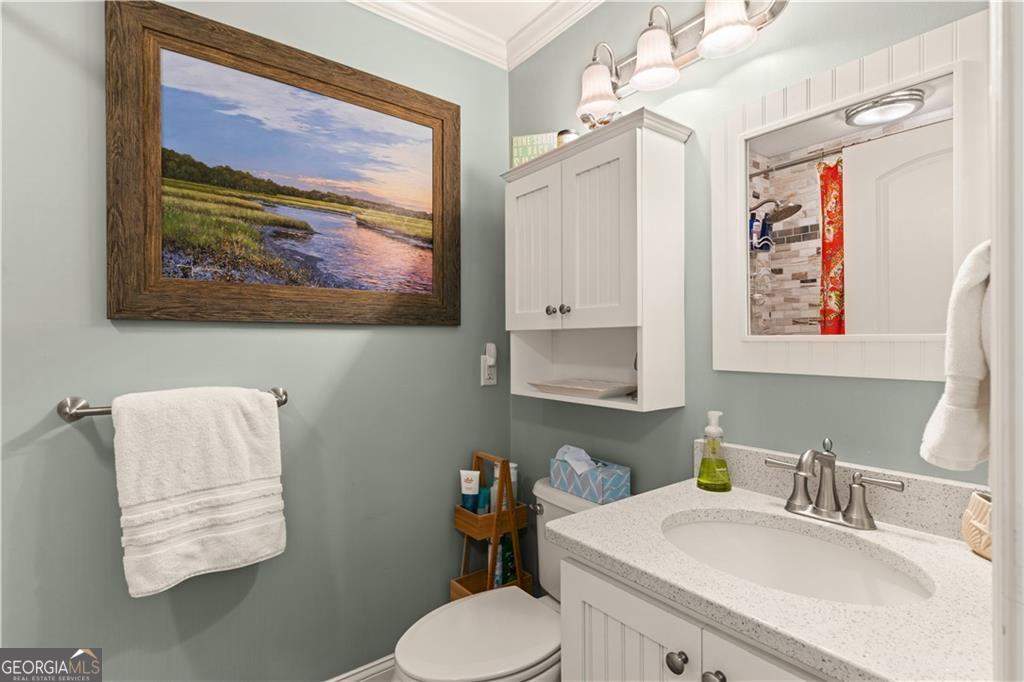 1035 Beach View Drive, Unit 201 St. Simons, GA 31522 - Photo 17 of 18 a bathroom with a toilet sink and mirror