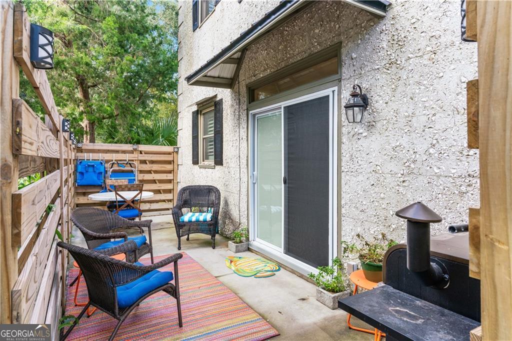 1035 Beach View Drive, Unit 201 St. Simons, GA 31522 - Photo 6 of 18 a table and chairs in front of a door
