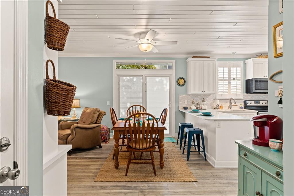 1035 Beach View Drive, Unit 201 St. Simons, GA 31522 - Photo 8 of 18 a living room with furniture a flat screen tv and a table