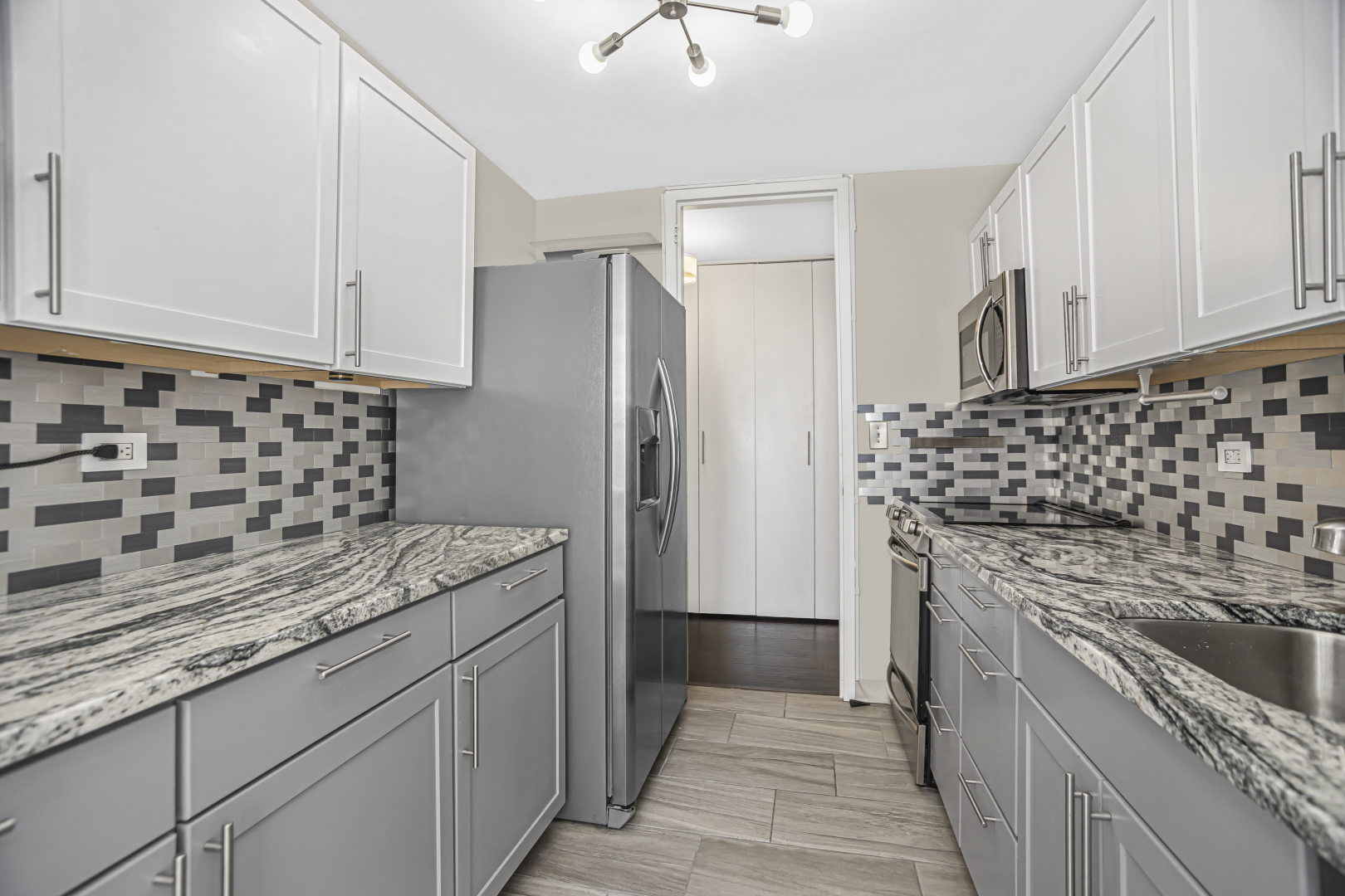 655 West Irving Park Road, Unit 1201 Chicago, IL 60613 - Photo 11 of 25 a kitchen with granite countertop a sink stove and refrigerator
