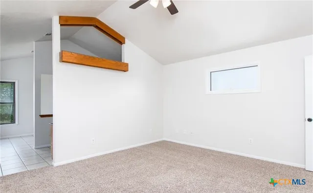 an empty room with white cabinet and windows