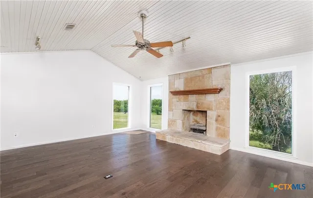 a view of an empty room with a fireplace and a window
