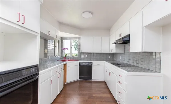 a kitchen with a sink stove and cabinets