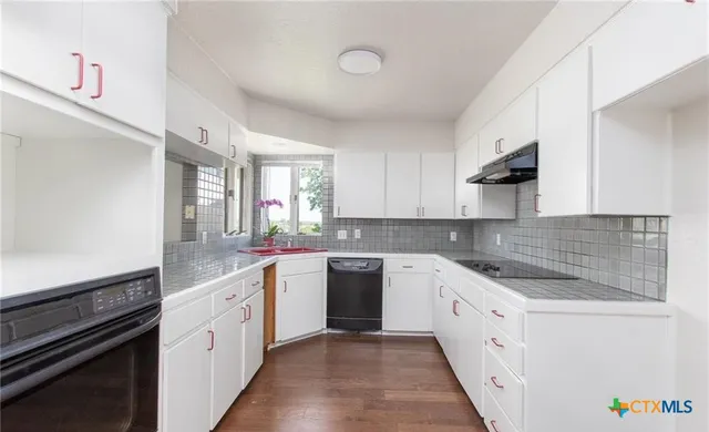 a kitchen with a sink stove and cabinets