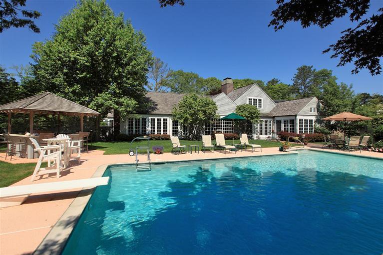 9 North Bay Road Osterville, MA 02655 - Photo 2 of 25 a view of a swimming pool with table and chairs under an umbrella
