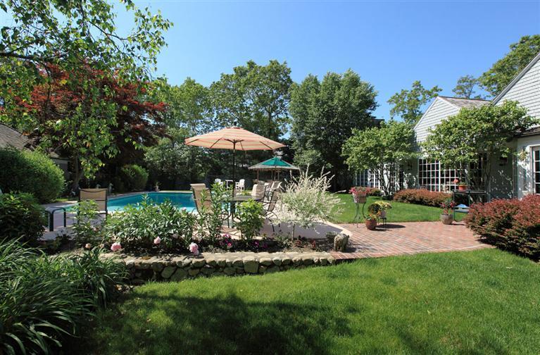 9 North Bay Road Osterville, MA 02655 - Photo 23 of 25 a view of a garden with a table and chairs under an umbrella