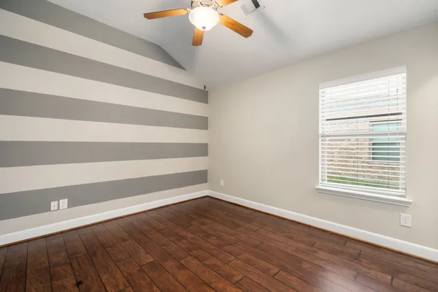 wooden floor in an empty room with a window