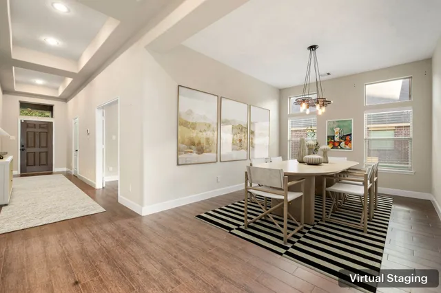 a dining room with wooden floor a chandelier a wooden table and chairs