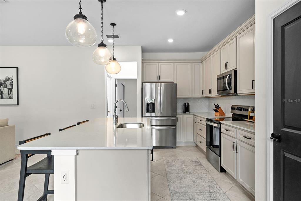 20402 Monza Loop Land O Lakes, FL 34638 - Photo 14 of 36 a kitchen with stainless steel appliances a stove refrigerator sink and microwave