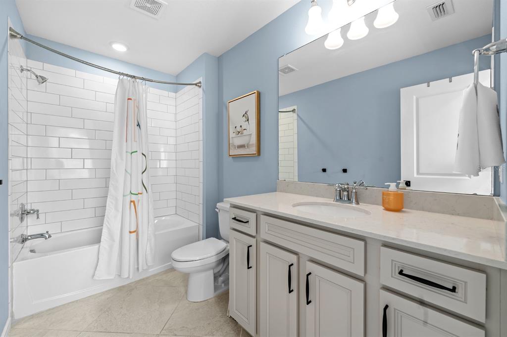 20402 Monza Loop Land O Lakes, FL 34638 - Photo 20 of 36 a bathroom with a sink a toilet and a large mirror