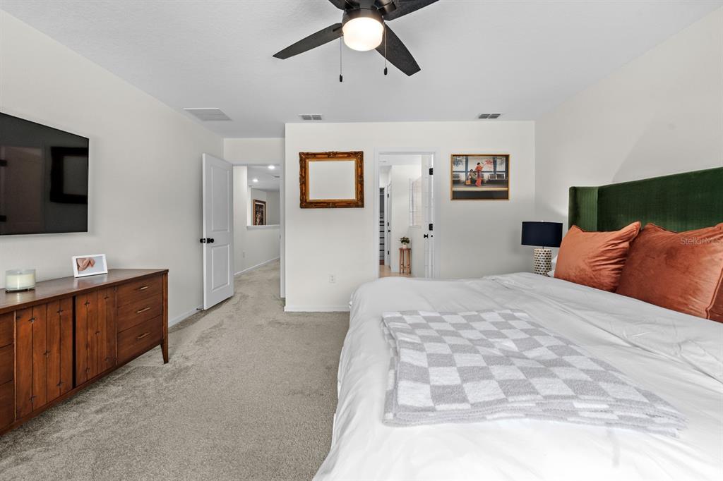 20402 Monza Loop Land O Lakes, FL 34638 - Photo 26 of 36 a spacious bedroom with a bed and a flat screen tv