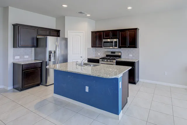 a kitchen with stainless steel appliances granite countertop a stove a sink and a refrigerator