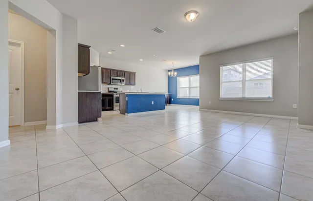 a view of kitchen with stainless steel appliances cabinets and flat screen tv