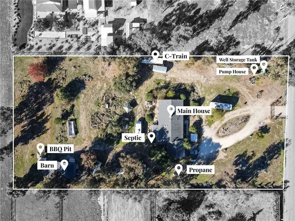 an aerial view of a house with a yard and large trees