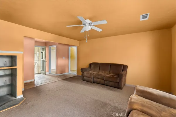 a living room with furniture and a ceiling fan