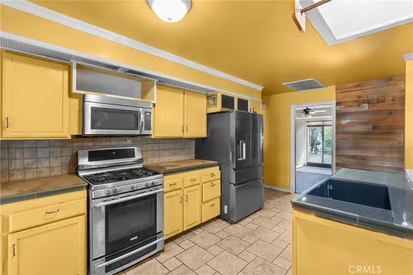 a kitchen with stainless steel appliances a stove a microwave and a refrigerator