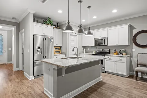 a kitchen with stainless steel appliances granite countertop a sink a stove a refrigerator and cabinets