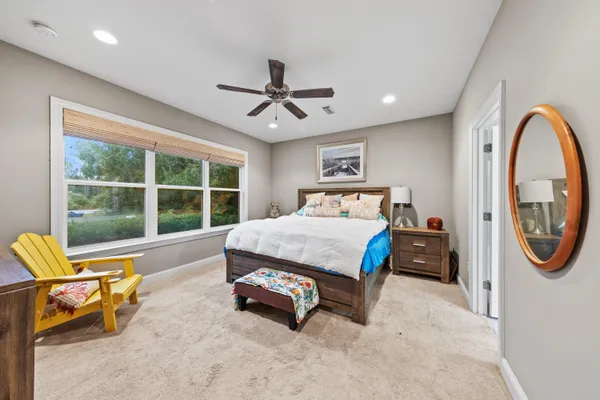 a bedroom with furniture and a large window