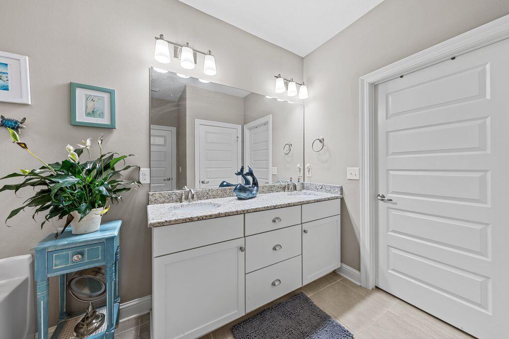 40 Oyster Boulevard Freeport, FL 32439 - Photo 18 of 30 a bathroom with a granite countertop sink a potted plant and a mirror