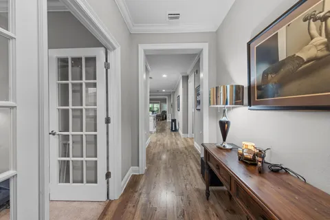 a view of a hallway with wooden floor and staircase