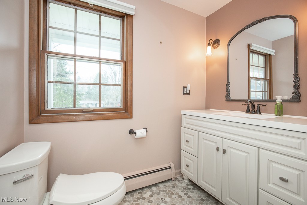 2969 Center Road Avon, OH 44011 - Photo 24 of 33 Bathroom with a wealth of natural light, toilet, vanity, and a baseboard heating unit