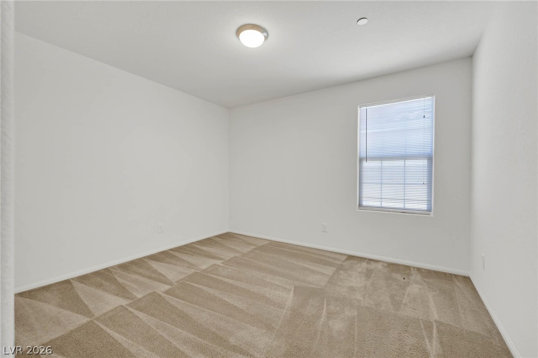 155 Fulgora Street Henderson, NV 89074 - Photo 13 of 30 An airy bedroom with fresh carpet and a well-lit window awaits your personal touch.
