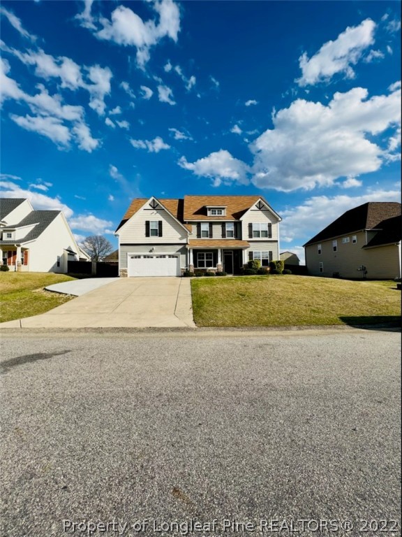 a view of a big house with a big yard and large trees