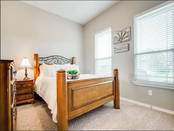 a bed sitting in a bedroom next to a window
