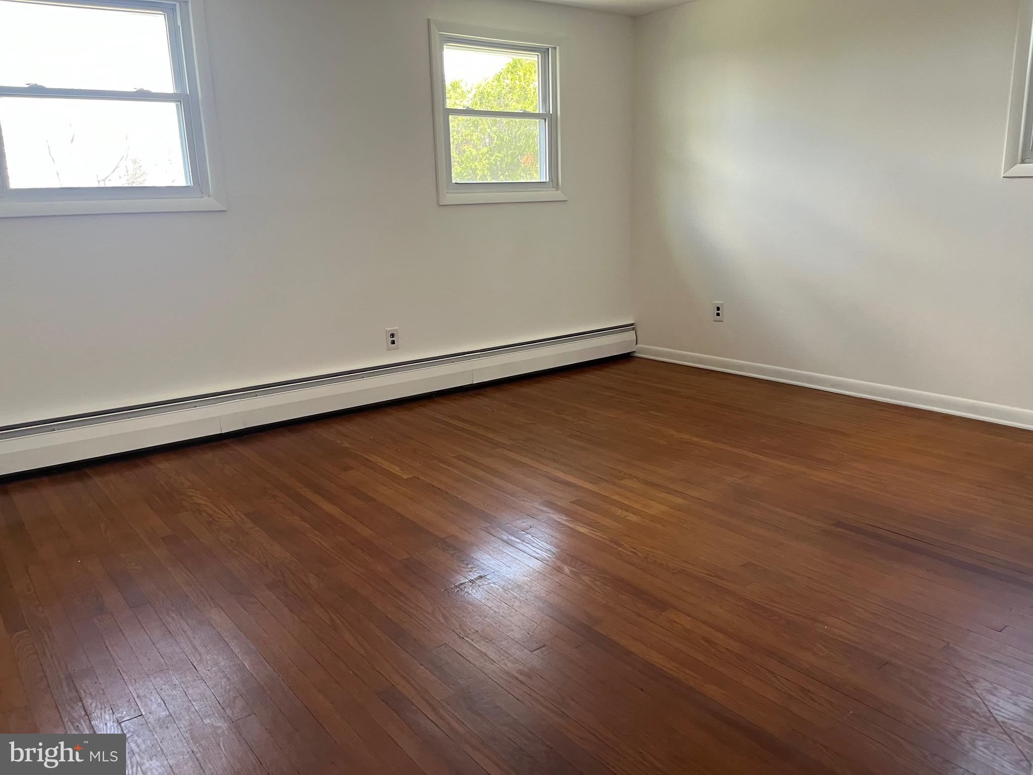 117 Spring Road Malvern, PA 19355 - Photo 22 of 25 an empty room with wooden floor and windows