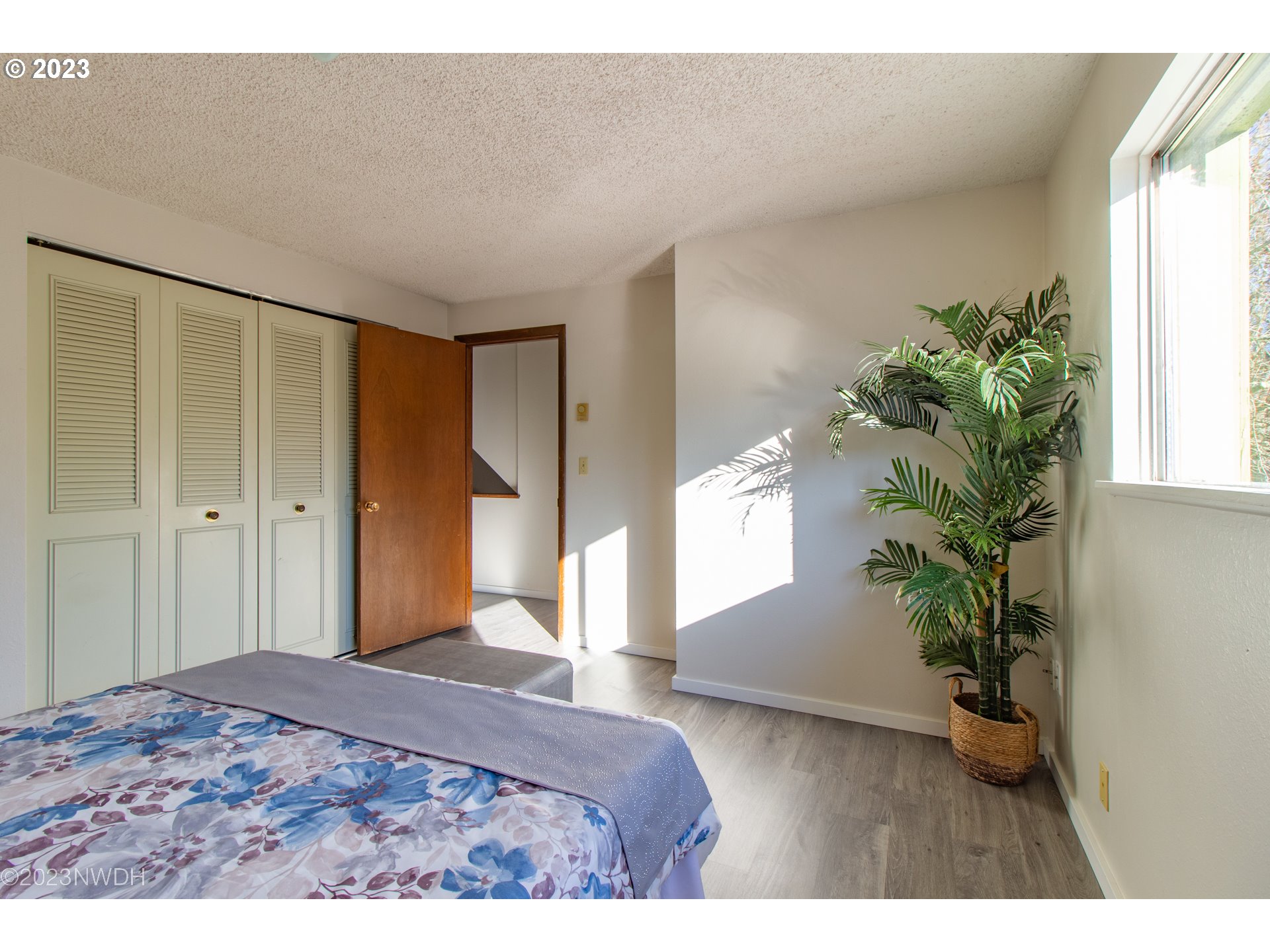 1302 Quaker Street Eugene, OR 97402 - Photo 17 of 28 a bedroom with a bed and a potted plant