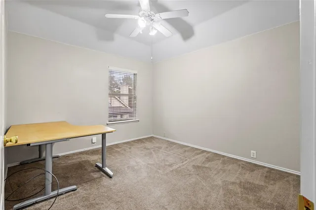an empty room with a window and a ceiling fan