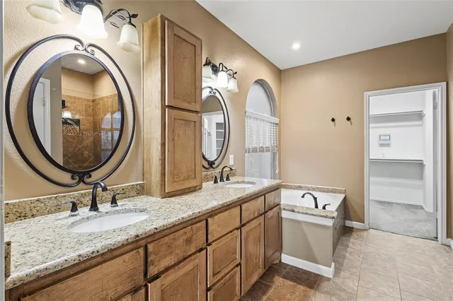 a bathroom with a granite countertop double vanity sink and a mirror
