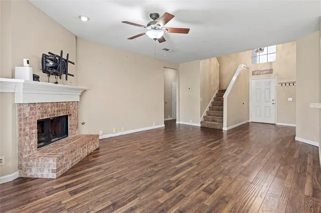a view of a livingroom with wooden floor and a ceiling fan