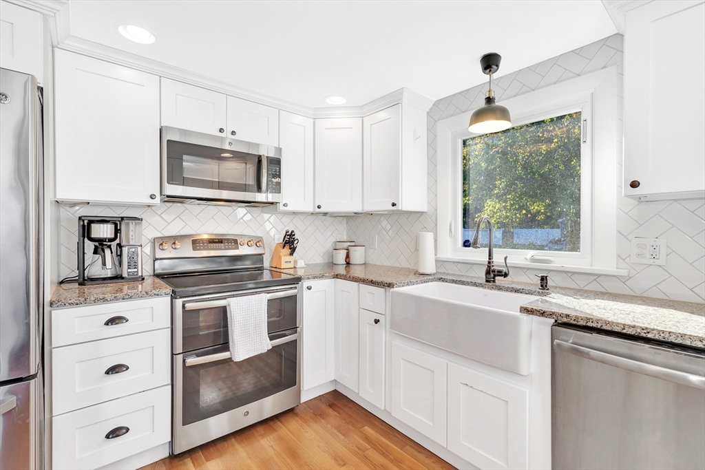 2 Morningside Drive Danvers, MA 01923 - Photo 6 of 25 a kitchen with stainless steel appliances granite countertop a sink a stove a microwave and wooden cabinets
