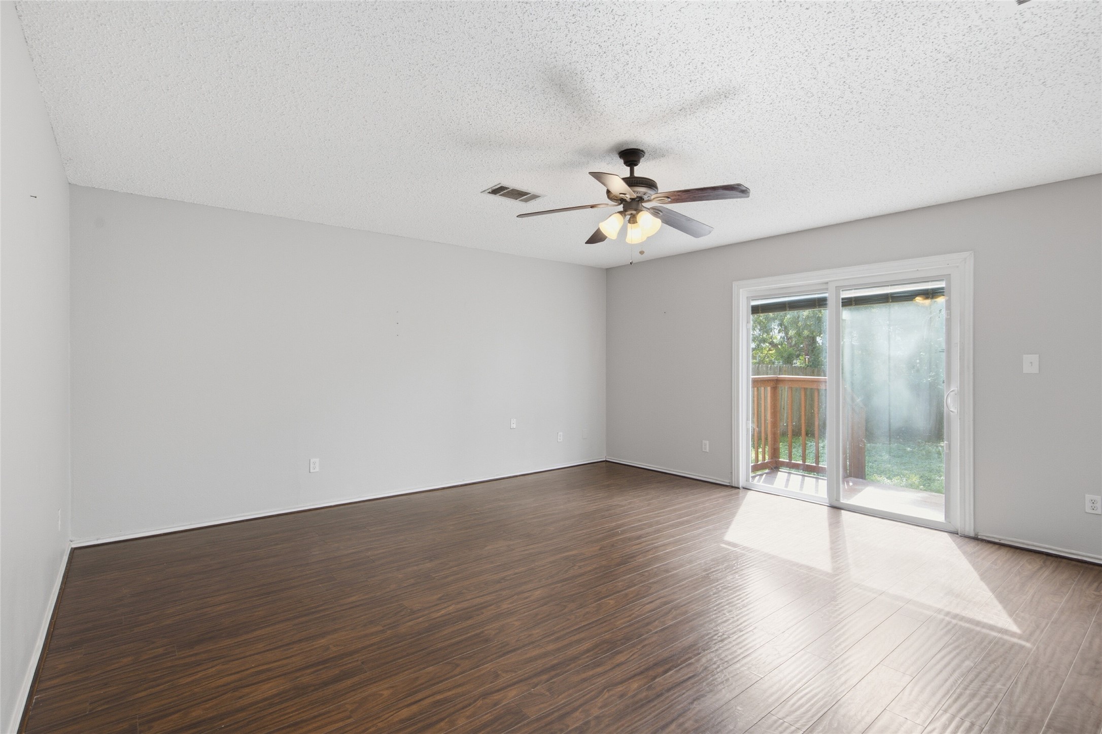 7900 Rosenberry Drive Austin, TX 78747 - Photo 7 of 27 Rich hardwood flooring complements a generously proportioned living area with outdoor access.
