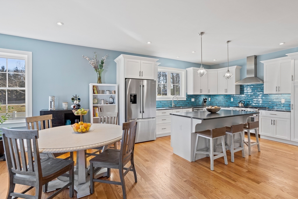 135 South Road Holden, MA 01520 - Photo 11 of 42 a kitchen with stainless steel appliances kitchen island granite countertop a dining table chairs and a refrigerator