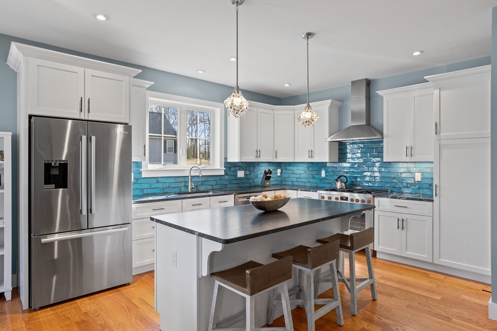 135 South Road Holden, MA 01520 - Photo 7 of 42 a kitchen with stainless steel appliances granite countertop a refrigerator a sink dishwasher a stove and white cabinets with wooden floor