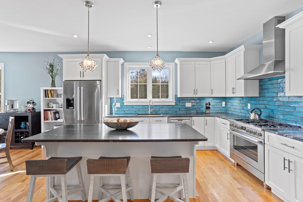 135 South Road Holden, MA 01520 - Photo 8 of 42 a kitchen with stainless steel appliances granite countertop a stove a refrigerator a oven a sink with a dining table and chairs