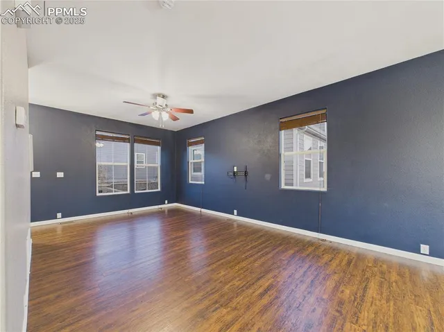 a view of an empty room with window and wooden floor