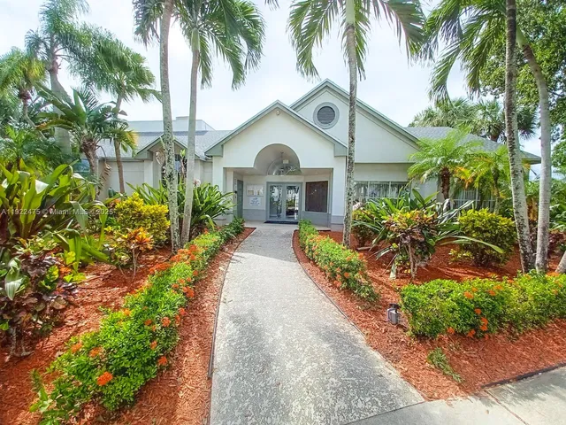 a front view of a house with a garden and patio