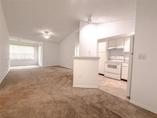 a view of a kitchen with white cabinets and a stove top oven