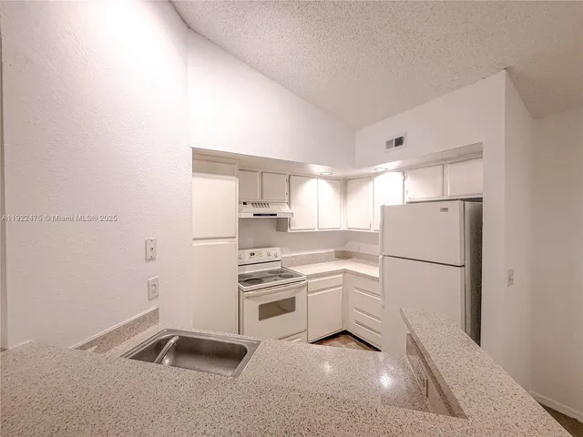 a kitchen with white cabinets and white appliances