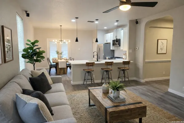 a living room with furniture kitchen view and a chandelier