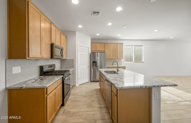 a kitchen with stainless steel appliances granite countertop a stove and a refrigerator